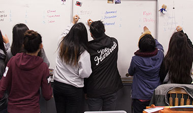 students writing on the board image